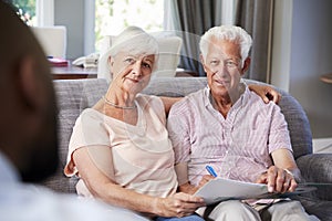 Happy senior couple taking financial advice at home