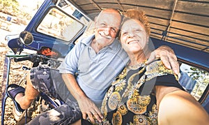 Happy senior couple taking selfie on tricycle in Philippines travel - Concept of active playful elderly during retirement -