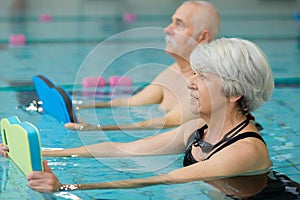 happy senior couple taking swimming lessons