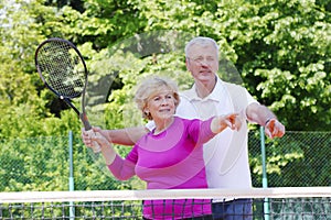 Happy senior couple at tennis court