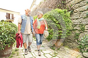 Happy senior couple walking holding hand in San Marino old town photo
