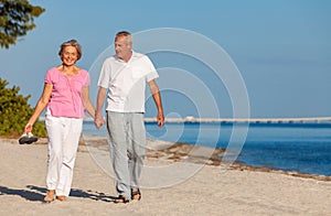 Happy Senior Couple Walking Holding Hands on a Beach