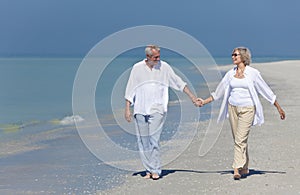 Happy Senior Couple Walking Holding Hands on Beach