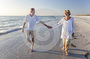 Happy Senior Couple Walking Holding Hands Tropical Beach photo