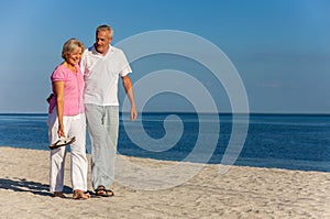 Happy Senior Couple Walking Laughing on a Beach