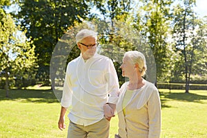 Happy senior couple walking at summer city park