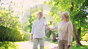 Happy senior couple walking at summer city park