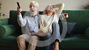 Happy senior couple watching sport tv game celebrating victory together