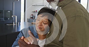 Happy senior diverse couple dancing in kitchen at retirement home