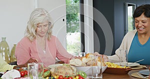 Happy senior diverse people praying before dinner at retirement home