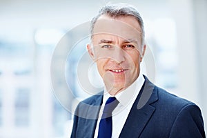 Happy senior executive indoors. Closeup of Business man smiling indoors.