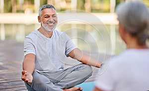 Happy senior family couple meditating together outdoors during morning yoga practice