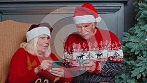 Happy senior family on mobile phone buy Christmas presents doing online ecommerce shopping purchase