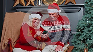 Happy senior family on mobile phone buy Christmas presents doing online ecommerce shopping purchase