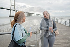 Happy senior friends talking on embankment