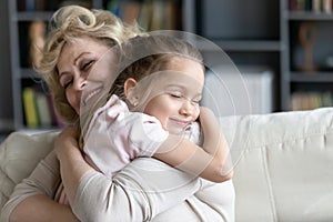 Happy senior granny cuddle with cute preschooler granddaughter photo