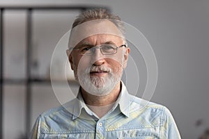 Happy senior grey haired 60s man with beard head shot
