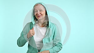 Happy Senior Lady Dancing, Radiating Joy and Energy in a Casual Hoodie