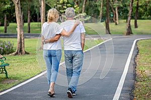 Happy senior loving couple relaxing at park embracing and walking together in morning time. old people  hugging and enjoying