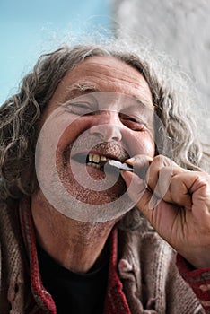 Happy senior man biting piece of chocolate