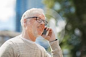 Happy senior man calling on smartphone in city