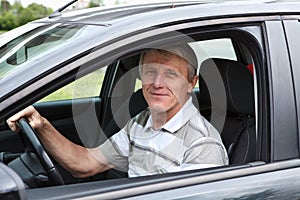 Happy senior man in car