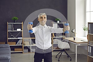 Happy senior man doing sports exercise during his working day in office workplace