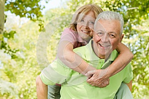 Happy senior man giving piggyback