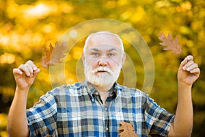 Happy senior man hiking in autumn in nature. Old man alone in autumn park.