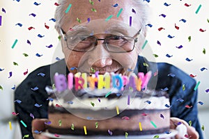 Happy senior man holding birthday cake