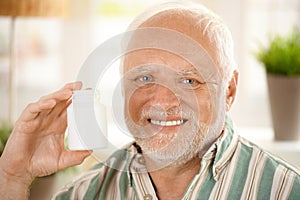 Happy senior man holding medication