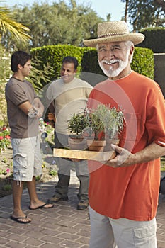 Happy Senior Man Holding Potted Plants