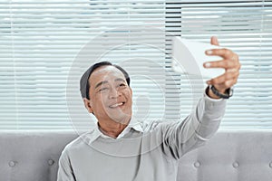 Happy Senior man Showing Toothy Smile While Taking Selfie Photo Using Mobile Phone