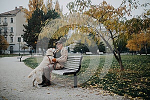 Happy senior man sitting on bench training and stroking his dog outdoors in city.