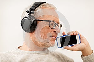 Happy senior man with smartphone and headphones