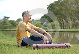 happy senior man in sportswear smiling and sitting in nature