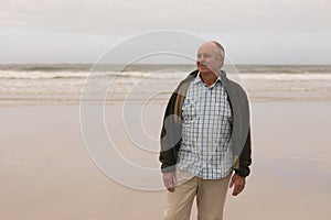 Happy senior man standing at the beach