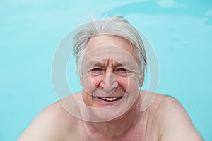 Happy senior man swimming in pool