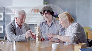 Happy senior man and woman playing Board game with his grandson