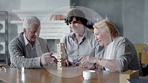 Happy senior man and woman playing Board game with his grandson