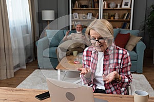 Happy senior mature woman wife remote working or distance learning online from home office using laptop computer video call while