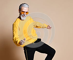 Happy senior millionaire man dancing in yellow sunglasses stylish fashionable men senior