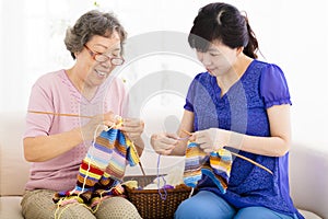 Happy Senior mother and daughter learning knitting