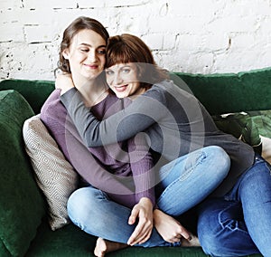 Happy senior mother embracing adult daughter laughing together, older lady hugging young woman