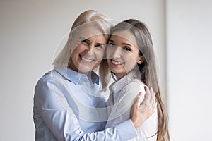 Happy senior mother embracing warmly her adult daughter