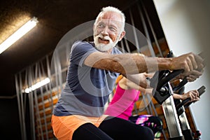 Happy senior people doing exercises in gym to stay fit