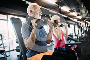 Happy senior people doing exercises in gym to stay fit