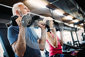 Happy senior people doing exercises in gym to stay fit