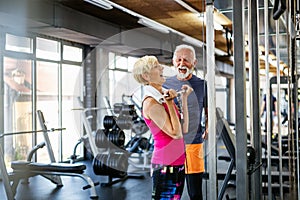 Happy senior people doing exercises in gym to stay fit. People sport concept.