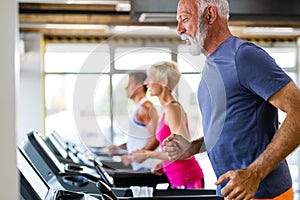 Happy senior people doing exercises in gym to stay fit. People sport concept.